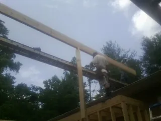 Carpenter setting a ridge beam over a new addition frame — Ice Dam Removal by Roofing Brothers in Mattawan